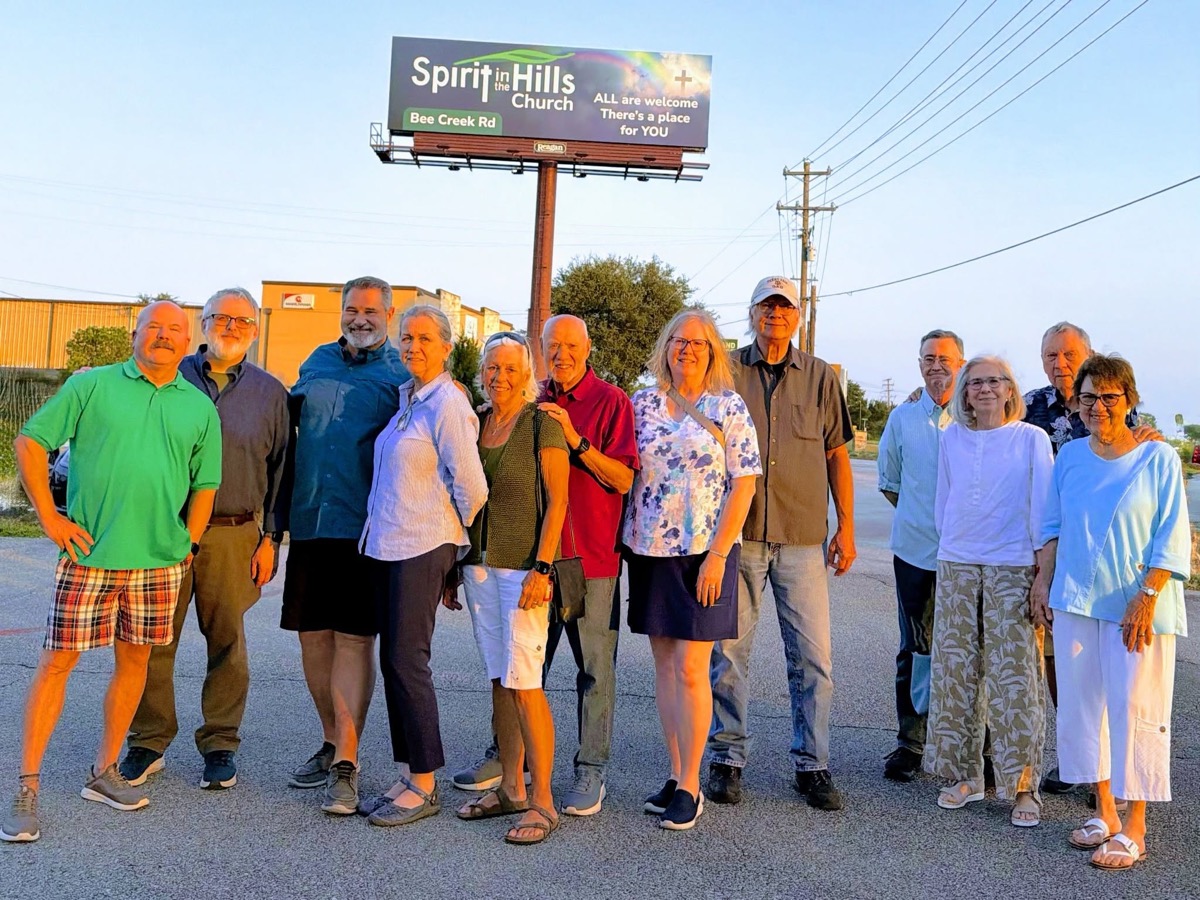 Members of our congregation gathered under the church billboard at dusk